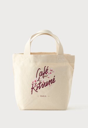 Borsa tote in tela beige con due manici, con scritta bordeaux "Café Kitsuné Paris" e illustrazioni rosa di fiori di ciliegio sul davanti.