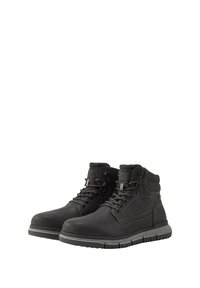 Par de botas altas de cuero negro con cuellos acolchados en gris y suelas de goma, con frente de cordones y detalles cosidos.