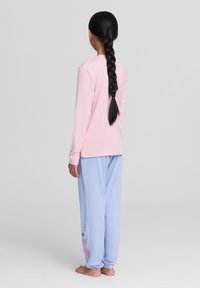 Maglietta rosa a maniche lunghe e pantaloni larghi color lavanda con grafica e testo di cartoni animati. Tessuto morbido, vestibilità comoda, progettata per il comfort.