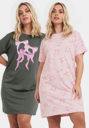 Due vestiti a T-shirt: uno verde oliva con grafica di un fiocco rosa, e uno rosa chiaro decorato con un motivo a fiocchi ripetuto. Tessuto di cotone, vestibilità morbida.