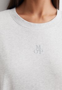 Felpa grigia chiaro con scollatura rotonda. Presenta una texture morbida e un logo ricamato "MOP" di un grigio leggermente più scuro sulla parte frontale.