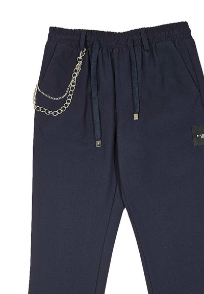 Pantaloni sportivi color blu scuro con vita elastica, coulisse, accentuazione di catena argentata, tasche laterali e un'etichetta sulla gamba sinistra.