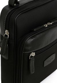 Borsa nera realizzata in nylon testurizzato e pelle liscia. Presenta dettagli grigi, numerosi scomparti con zip e una leggera lucentezza.
