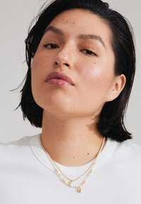 Valgt, gold-coloured