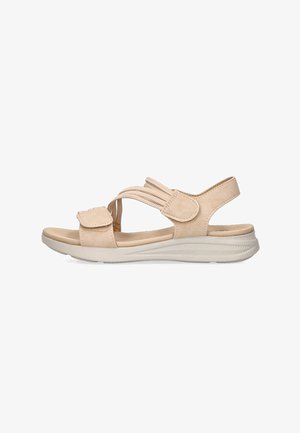 Sandalias de tela beige con correas ajustables, suela acolchada y suela de goma texturizada, que presentan un diseño minimalista y punta abierta.