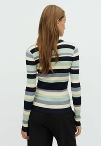 Maglione a maniche lunghe a coste con strisce orizzontali in verde menta, blu navy e crema. Presenta una silhouette aderente e un collo rotondo.
