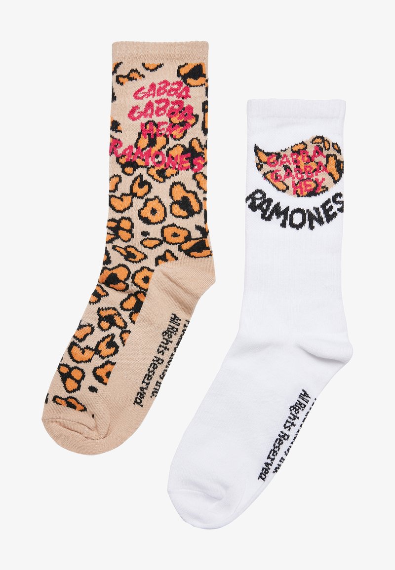 Leopard print sock in beige with black and orange accents; white sock features a graphic design and text. Both have knitted textures.