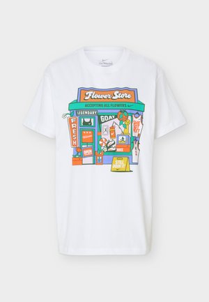 Hvid T-shirt med korte ærmer med farverig grafik af en blomsterbutiks facade, sportsudstyr og tekst, herunder "Flower Store" og "Still Doin' It."