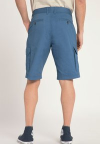 Pantalones cortos cargo azules, confeccionados en un material ligero, que cuentan con dos bolsillos laterales y dos bolsillos traseros con cierres de botón. Corte a la altura de la rodilla.