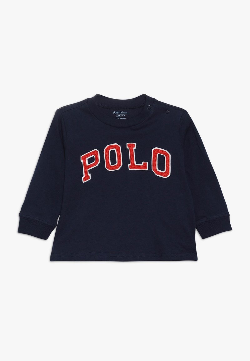 Námořnická košile s dlouhým rukávem vyrobená z bavlny, s nápisem "POLO" velkými červenými a bílými písmeny. Obsahuje patentní zapínání na rameni a žebrované manžety.