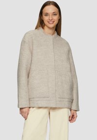 Beige wolmix jas met een ronde halslijn, twee voorzakken en een relaxte pasvorm. Soepele textuur en minimalistisch ontwerp.