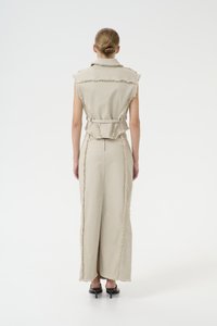 Robe beige sans manches avec un bord effiloché, taille cintrée et une silhouette droite, dotée d'une fermeture éclair au dos et de fentes sur les côtés.