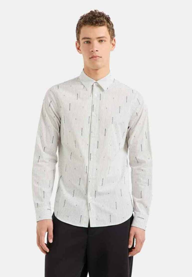 Camicia bianca con bottoni, caratterizzata da strisce verticali nere e linee nere di accento sparse. Maniche lunghe, colletto standard, design slim fit.