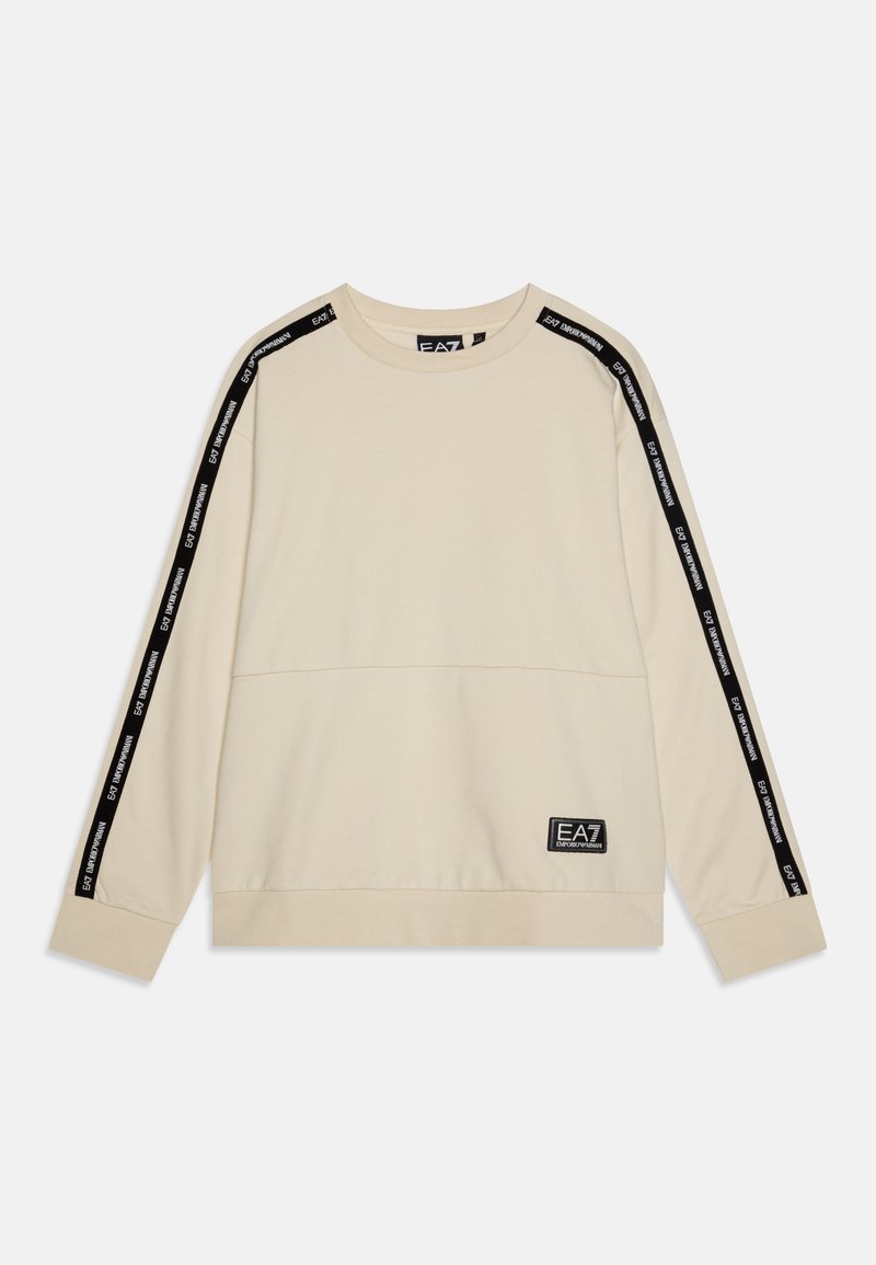 Beige sweatshirt med lange ermer, sorte striper på skuldrene, logopatch ved sømmen, og rund halslinning. Myk stofftekstur.