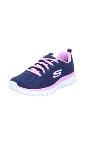 Marineblauw sportieve schoen met roze accenten, bovenwerk van mesh, platte veters en een witte, gestructureerde zool. Heeft een logo aan de zijkant.