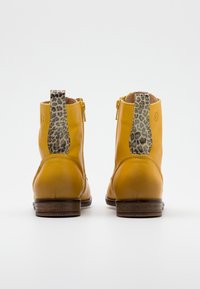 Żółte skórzane botki za kostkę z materiałowymi akcentami w leopardzi wzór z tyłu, z bocznym zamkiem błyskawicznym i zaplecionym drewnianym obcasem.