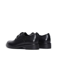 Zapatos oxford de cuero negro con textura suave, punta redonda y tacón pequeño. Presentan ojetes y cordones, diseñados para vestimenta formal.