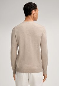 Maglione leggero beige, con scollo rotondo, maniche lunghe, polsini e bordo a costine, texture liscia, motivo sottile, visto da dietro.