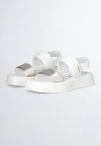 Sandali bianchi e metallici in argento con cinturini larghi, design open toe, suola piattaforma e dettaglio del logo impresso sul lato. Texture antiscivolo.