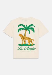 Kremna majica s kratkimi rokavi, na kateri je zelena palma in rumeni leopard z črnimi pikami, pod njimi pa je napis "Los Angeles" v zeleni barvi.