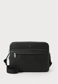 Borsa a tracolla nera in pelle con superficie texture, tasca frontale con zip, accessori in argento e tracolla regolabile. Forma rettangolare.