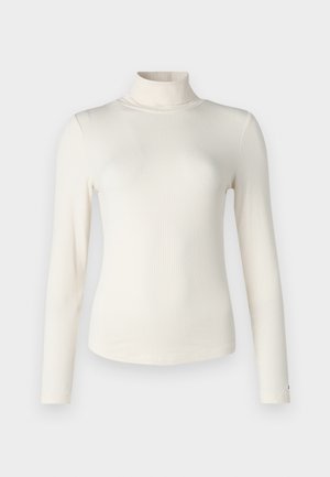 Top de cuello alto de manga larga acanalado en blanco, con un diseño ajustado y textura suave. Los detalles de costura a lo largo de los hombros añaden una sutil definición.