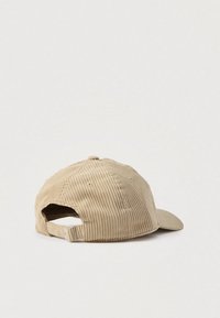 Beige kordfløyel baseballcap med buet brem, justerbar stropp bak og teksturert vertikalt ribbemønster.