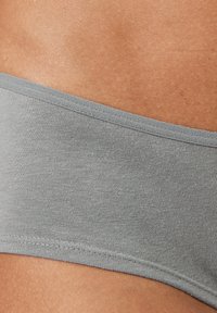 Grijze stoffen bikini onderkant met een zachte textuur, gladde afwerking en smalle tailleband. Naaddetails zijn zichtbaar langs de randen.