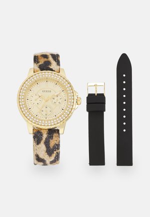 Goldfarbene Uhr mit einem Leopardenmuster-Stoffarmband, Kristallverzierungen auf der Lünette und einem schwarzen, wechselbaren Silikonarmband.