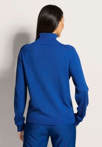 Blauer Rollkragenpullover mit gerippten Bündchen und Saum, aus weichem Material gefertigt, mit figurnahen Design und nahtlosen Schultern.