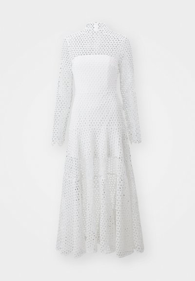 Biała sukienka z długimi rękawami i wysokim dekoltem, wykonana z tkaniny w okrągły wzór koronkowy, z luźnym, warstwowym dołem.