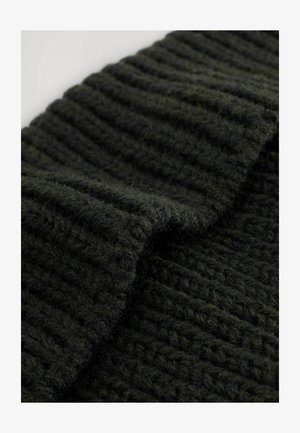 Tessuto a maglia verde scuro con una texture a coste, caratterizzato da filati spessi e morbidi che creano un aspetto accogliente. Il bordo è leggermente arricciato.