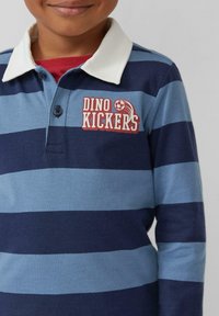 Langsleeve polo shirt met marineblauwe en lichtblauwe strepen, een witte kraag en een "DINO KICKERS" logo met een voetbalafbeelding.