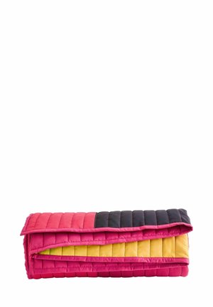 Trapunta rettangolare piegata con cuciture orizzontali in blocchi di colore rosa acceso, giallo e nero su sfondo bianco.