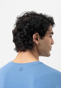 Blauwe biologische katoen t-shirt met een ronde halslijn en een geprinte label aan de achterkant; zachte textuur en casual pasvorm.