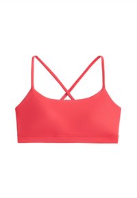 Coral pink sports bra with thin straps crossing at the back, smooth fabric, and a wide underbust band, shown on a white background.