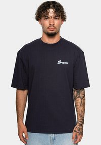 Mørkeblå oversized t-shirt lavet af bomuld, med et hvidt "Dropsize" logo på brystet, rund halsudskæring og korte ærmer.