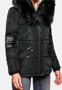 Giacca a vento nera con cappuccio in pelliccia sintetica, chiusura frontale con zip, maniche a coste e tasche laterali con chiusura a bottone. Tessuto liscio e lucido.