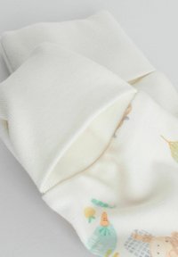 Miękkie białe niemowlęce rękawiczki z podwiniętymi mankietami, z drobnymi, pastelowymi nadrukami warzyw i zwierząt na jednej rękawiczce.