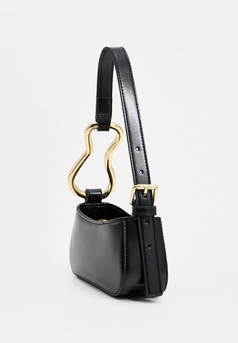 Schwarze Lederhandtasche mit glatter Textur, die ein markantes goldfarbenes Hardware-Element in einzigartiger Form und einen verstellbaren Schulterriemen aufweist.