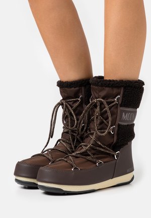Brown winter boots with a soft, fuzzy collar and textured leather finish. Features lacing and a padded lining for insulation.