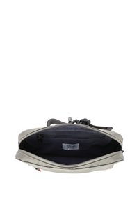 Borsa in tessuto grigio chiaro con chiusura a zip. Presenta un interno scuro e un'etichetta del logo visibile. Manico testurizzato e tasca con zip interna.