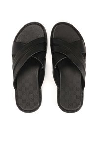 Sandale negre cu talpă plată, având două curele încrucișate, un șezut texturat cu un model de logo și o talpă plată.