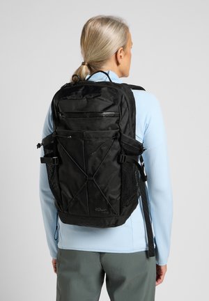 Schwarzer Rucksack mit mehreren Reißverschlussfächern, Netztaschen an den Seiten, verstärkten Trägern und einem minimalistischen Design mit strukturierter Oberfläche.