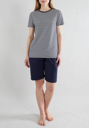 Gestreept katoenen t-shirt met marineblauwe en witte horizontale lijnen, gecombineerd met marineblauwe shorts. Beide kledingstukken hebben een relaxte pasvorm en minimale details.