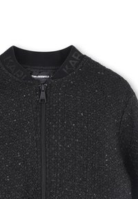 Zwarte bomberjack van een textuurstof met subtiele pailletten, een ritssluiting en een geribbelde kraag met het merkembleem.