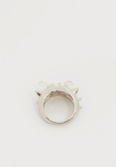 Δαχτυλίδι από ασημένιο μέταλλο με πολλούς ακίδες που προεξέχουν από την εξωτερική του επιφάνεια, απεικονισμένο σε απλό λευκό φόντο.