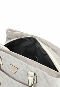 Bolso de mano color beige claro con un patrón de logotipos, que cuenta con un cierre de cremallera y un interior negro. Incluye herrajes plateados y un detalle del logotipo en la parte frontal.