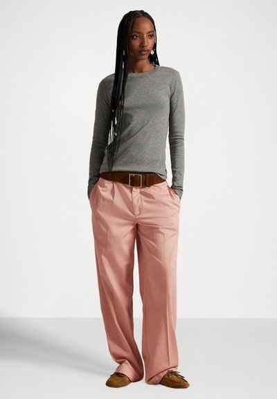 Szary długi rękaw, luźne jasnoróżowe spodnie, brązowy pasek i brązowe buty. Gładka faktura i luźny fason. Minimalistyczny design.