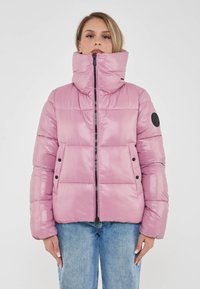Giacca puffer rosa con alto colletto, chiusura con zip, tasche laterali e dettagli neri. Materiale liscio e lucido con un aspetto e una sensazione trapuntati.